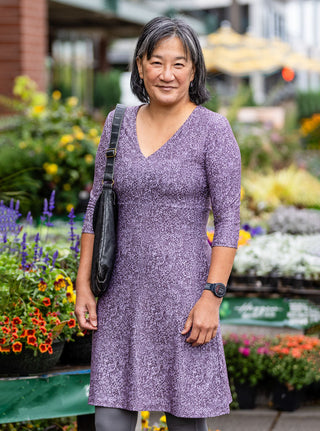 woman in red 3/4 length dress in front of door