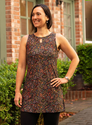 women in exercise dress balancing on one leg in front of water